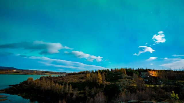 Shimmering aurora borealis or northern lights reflecting on Lagerfljot River, Egilsstadir, Iceland - time apse in autumn