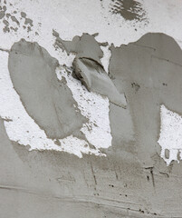 A wall with a grey paint and some white spots