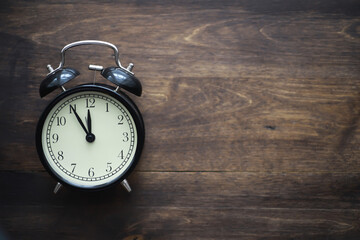 Vintage Black Alarm Clock on Wooden Surface Representing Time and Nostalgia