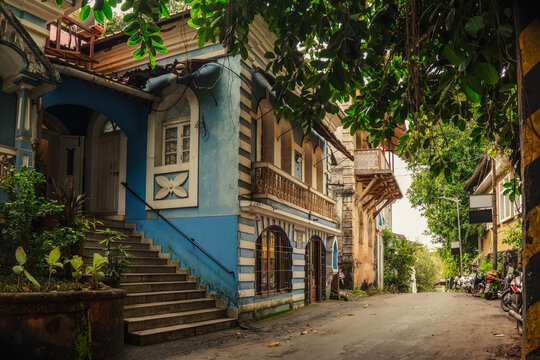Street of Panaji in Goa, India. Bright colourful facades and green trees