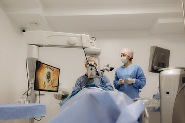 A surgeon looks through a microscope in the operating room. A doctor uses a microscope during eye surgery or diagnosis, cataract treatment and diopter correction.
