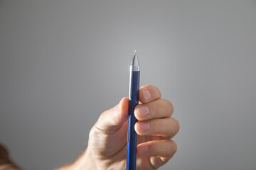 Male hand with a pen writes in empty screen.