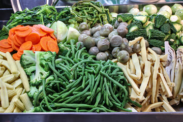 Boiled vegetables sold in the market include thinly sliced ​​carrots, broccoli, baby corn, green beans, bamboo shoots, bitter melon, and eggplant, which are all healthy vegetables.