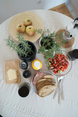Breakfast Spread with Salad, Bread, Apples, and Fresh Herbs