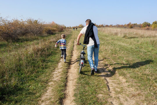 Joyful moments: dad helps son master bicycle riding