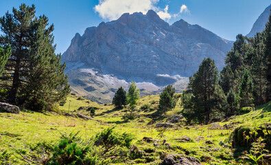 French Pyrenees mountains. the mountain range with a lush green valley in between. Sky is clear and the sun is shining brightly