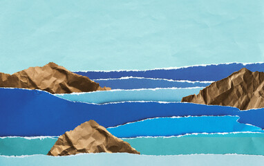 Hand made creative collage seascape from torn colored paper in blue water colors with copy space. Ocean waves with cliffs.