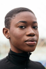 Obraz premium close up portrait of a young tender ethnic female with short hair looking at camera with blurred background