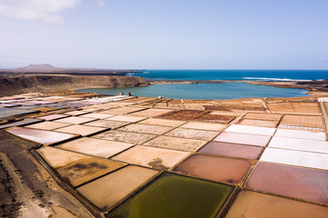 colorful salt flats against lagoon and ocean on sunny day in Yaiza, Lanzarote at Canary Islands in Spain, concept of nature and marine lifestyle