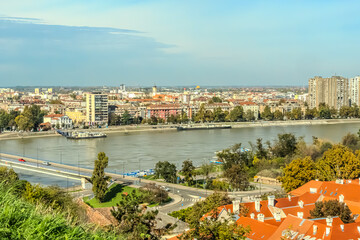 Naklejka premium cityscape of Novi Sad from the historic vantage point of Petrovaradin, where ancient towers and charming streets intertwine with the gentle flow of the Danube.