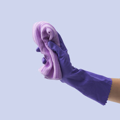 Female hand wearing a cleaning glove and holding a cloth
