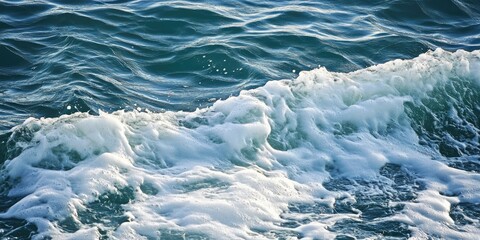 Fototapeta premium A detailed view of tranquil ocean waves featuring tiny white frothy crests on the surface, capturing the serenity of the seas gentle motion.