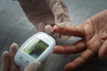 doctor using glucometer checking blood sugar level of senior woman. diabetes concept