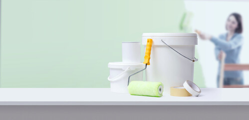 Professional painting equipment and woman painting her home