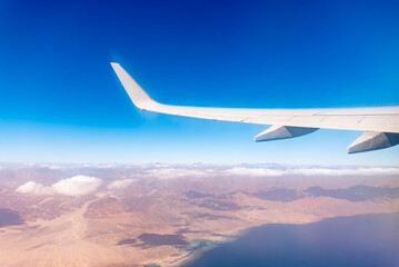 Fototapeta premium View from the airplane window of the mountains and sea resort with corals in Egypt, Sharm El Sheikh.Flight