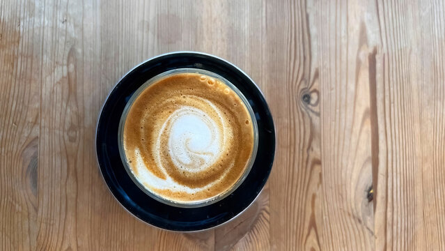 A cortado drink served on a wooden table.