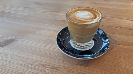 A cortado drink served on a wooden table.