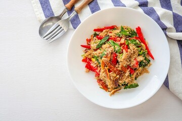 stir fried Thai basil with crab in a white ceramic plate on white background