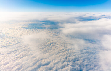 View from the airplane window at a beautiful cloudy sky and the airplane wing