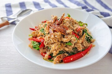 stir fried Thai basil with crab in a white ceramic plate on white background