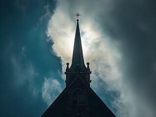 Tall church spire touches the sky with dramatic clouds in the background on a sunny day.