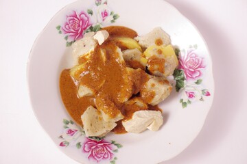 a siomay with fish balls, potatoes, peanut sausage, and tofu on a white background isolated