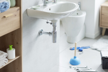 Leaking bathroom sink and plumber tools