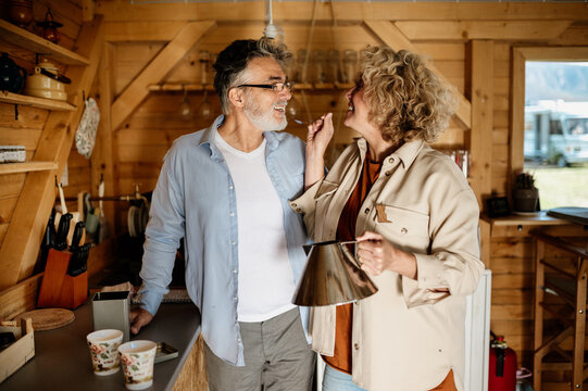 Middle aged woman with curly hair make coffee for her husband closeup.