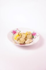 a siomay with fish balls, potatoes and tofu on a white background isolated