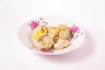 a siomay with fish balls, potatoes and tofu on a white background isolated