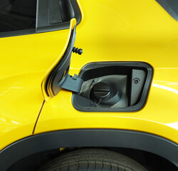 Open fuel tank door on yellow car for fueling gasoline or diesel open. Transportation industry concept  