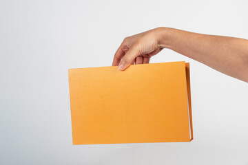 Blank book cover in hand on white background.