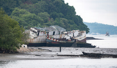 The illegal cargo ships have been left abandoned on the shore near the fishing pier in Phuket, Thailand.