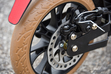 Disc brake on the rear wheel of a scooter. Close-up.