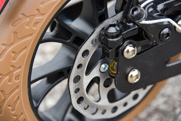 Disc brake on the rear wheel of a scooter. Close-up.