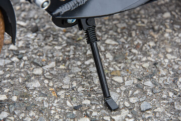 The scooter's footrest is on the asphalt.