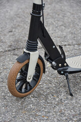Front wheel of a scooter on asphalt. Close-up.