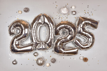 2025 Silver Balloon Numbers with Holiday Decorations. Festive New Year Celebration Theme with Metallic Ornaments and Star Confetti