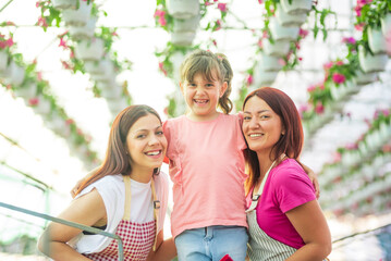 Family of gardeners smiling and posing in a greenhouse