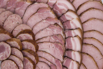 Close-up of assorted smoked sausages and ham slices