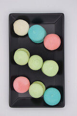 Colorful French macarons on a black plate