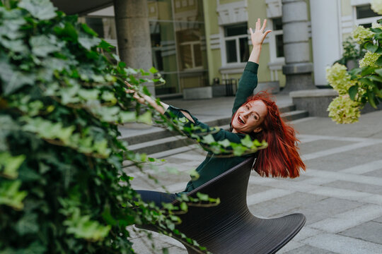 Cheerful entrepreneur enjoying on spun chair outside office