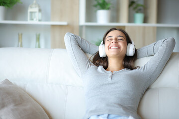 Happy woman at home listening music with headphone resting