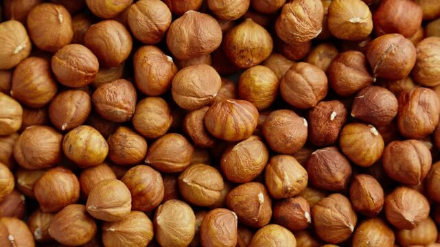 Hazelnuts rotating. Organic snack. Pile of hazelnuts without shell. Vegan food. Top view. Healthy nutrition. Peeled brown nut. Hazelnut kernels rotating. Slider dolly shot. Zoom out. 4K, UHD