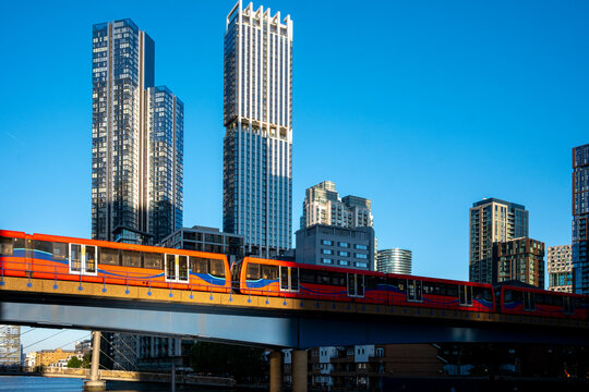 A vibrant city skyline view featuring a train crossing a bridge against the backdrop of tall skyscrapers at sunset, symbolizing connectivity and urban progress  in London UK