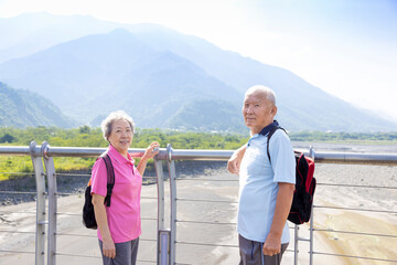 Travel and tourism. Senior family couple walking together on bridge