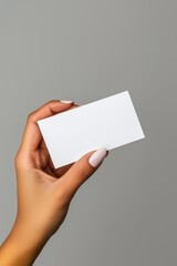 Obraz premium A hand holding a blank business card against a neutral background for branding and design concepts