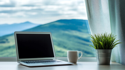 Minimalist workspace with laptop, coffee mug, and potted plant by window with mountain view