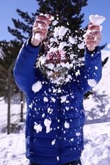 Person playing with snow on a sunny winter day