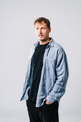 Confident young man in casual indoor outfit. A young man stands with his hands in pockets, wearing a casual outfit in a bright, indoor space.